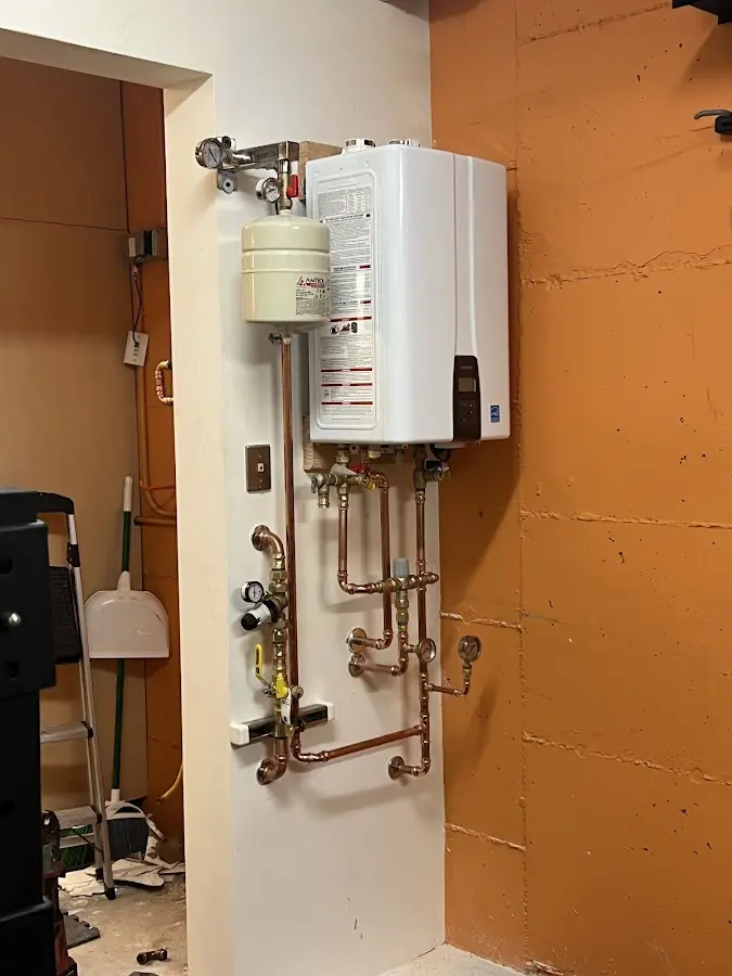 Plumbing technician inspecting water heater connections in Dunkirk